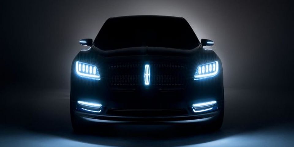 auto color negro parte frontal con luces encendidas