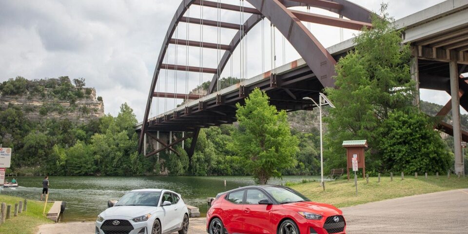 dos autos hyundai color rojo y plomo cerca del rio