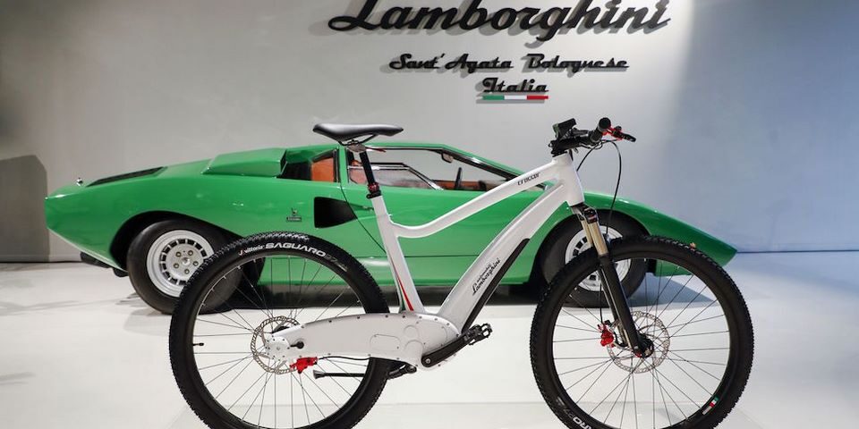 bicicleta colo blanca con fondo de auto color verde
