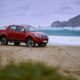 camioneta chevrolet color rojo en la arena junto al mar