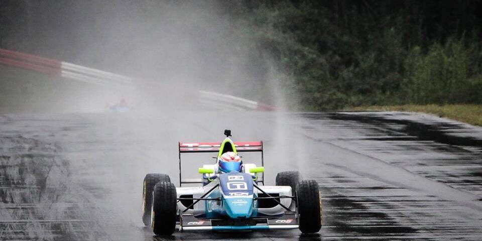 auto formula1 pasando por lluvia de agua