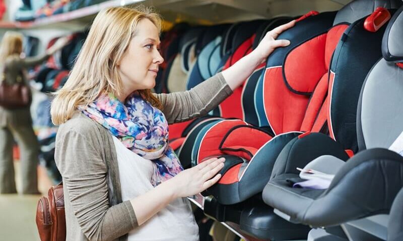 mujer viendo asientos para niños de autos